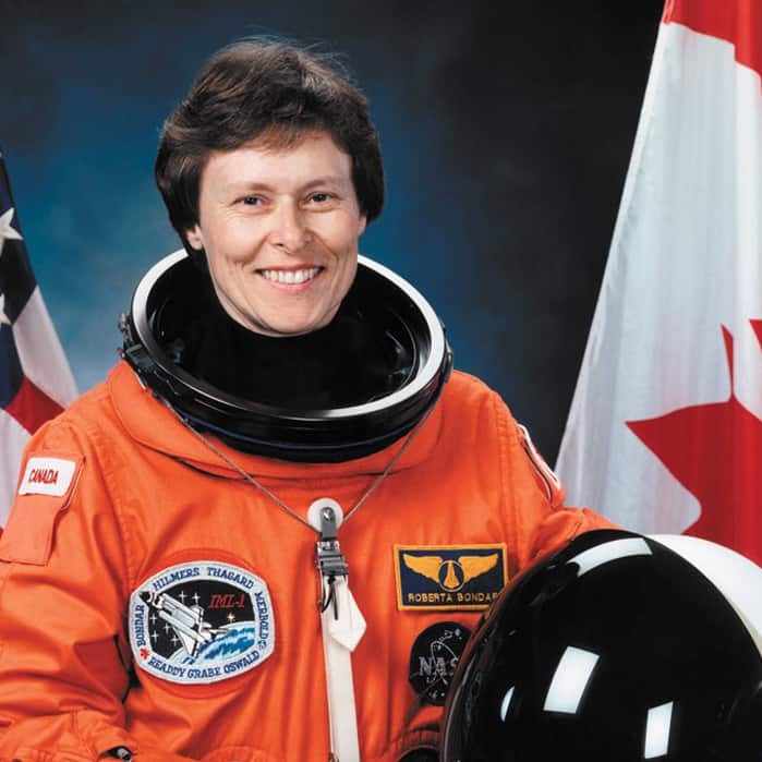 http://alt=%20Headshot%20of%20Canadian%20astronaut%20Roberta%20Bondar%20wearing%20an%20astronaut%20suit%20with%20Canadian%20flags%20in%20the%20background.