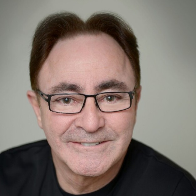 alt= Headshot of a man, Robert Hirschberg, wearing glasses and a black shirt