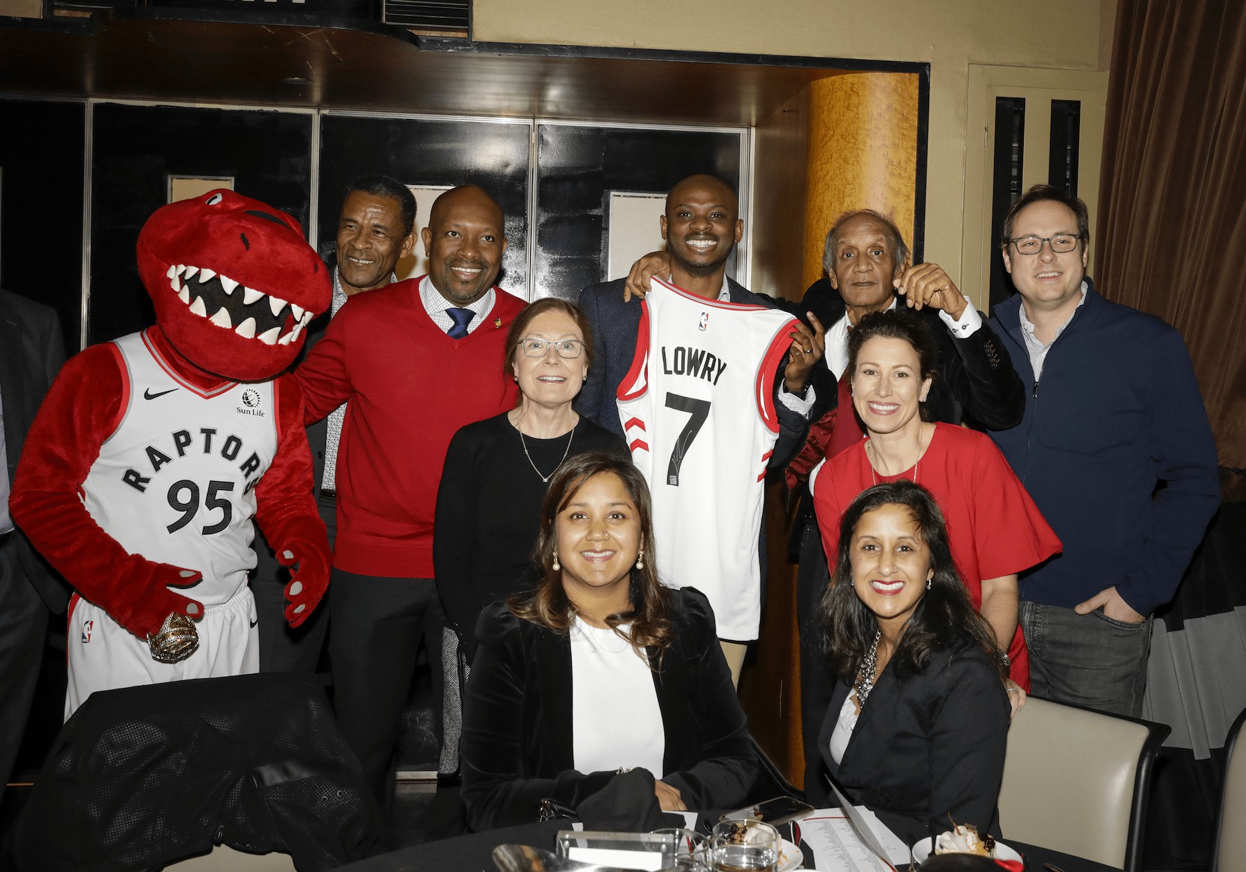 alt= The red raptor mascot for the Toronto Raptors with 2019 Nation Builder Award event guests.