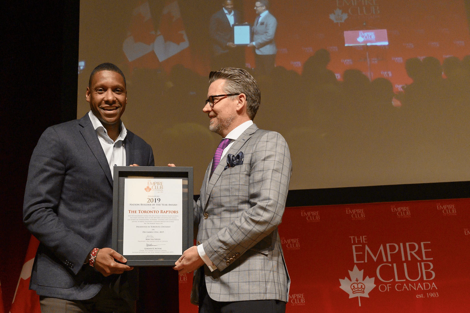 alt=Man accepting the Nation Builder 2019 Award on behalf of the Toronto Raptors on stage.