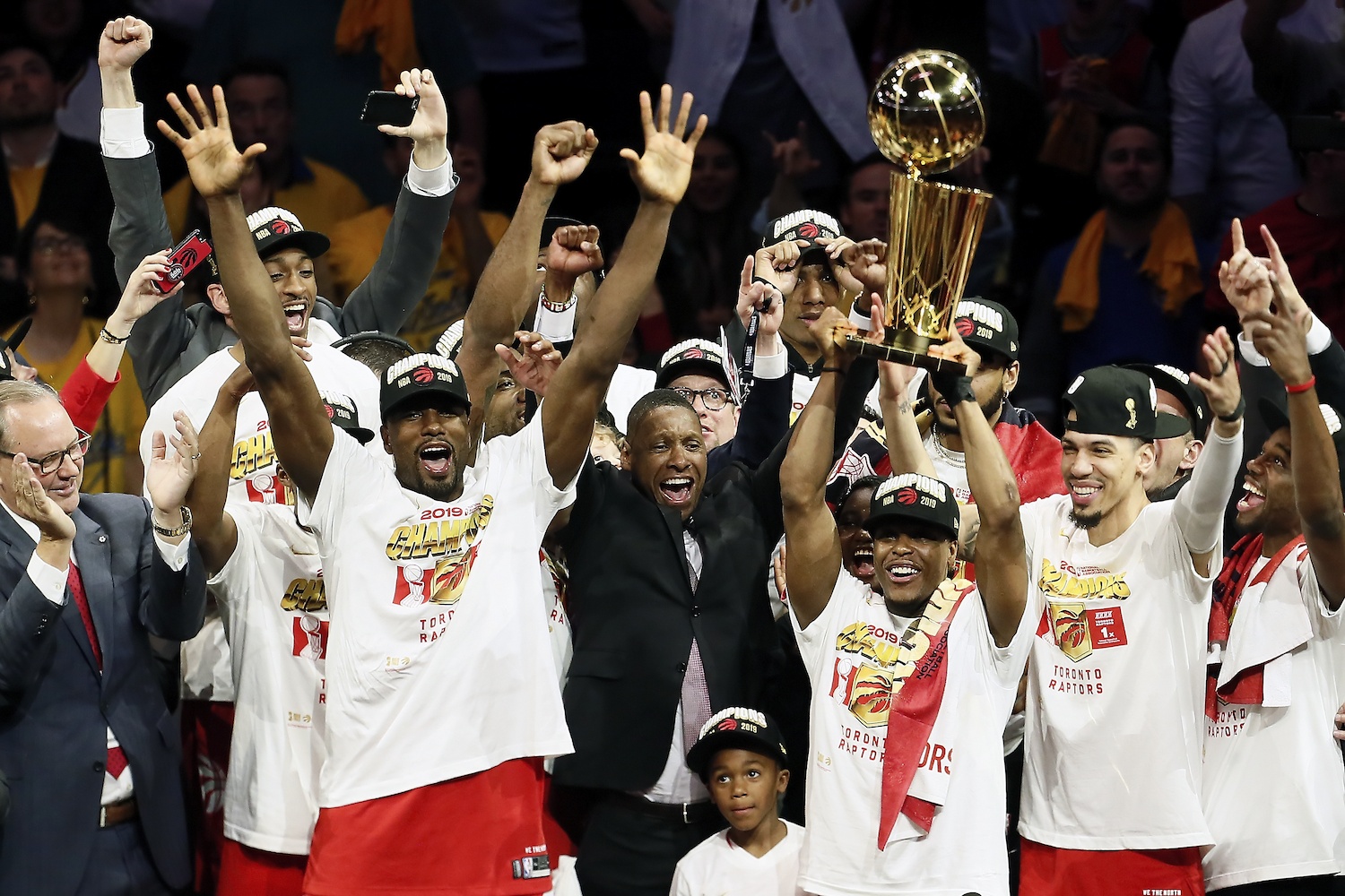 alt= Toronto Raptors players and team president, Masai Ujiri, with the Larry O'Brien NBA Championship Trophy on June 13, 2019.