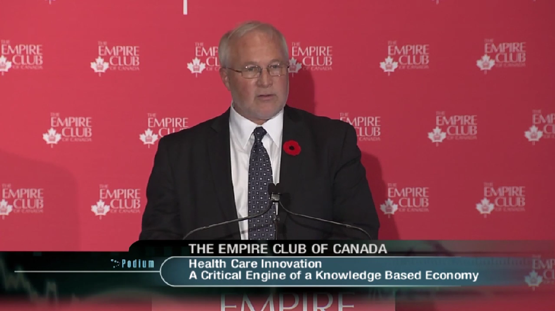 a man in a dark suit delivering a keynote speech from the Empire Club of Canada's podium