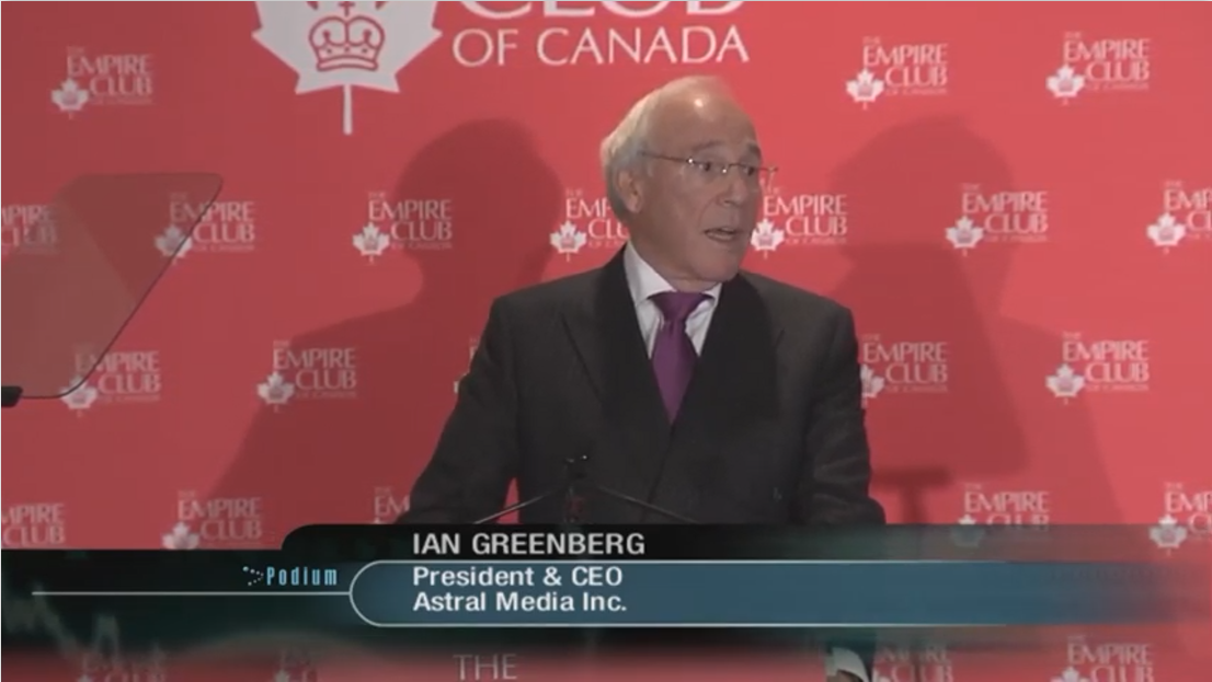 a man in a dark suit delivering a keynote speech at the Empire Club of Canada podium