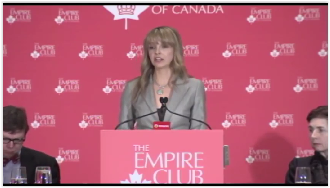 a female speaker in a grey suit delivering a keynote presentation at the Empire Club of Canada podiu