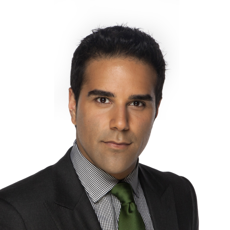 A man, Omar Sachedina, in grey shirt, green tie and black jacket