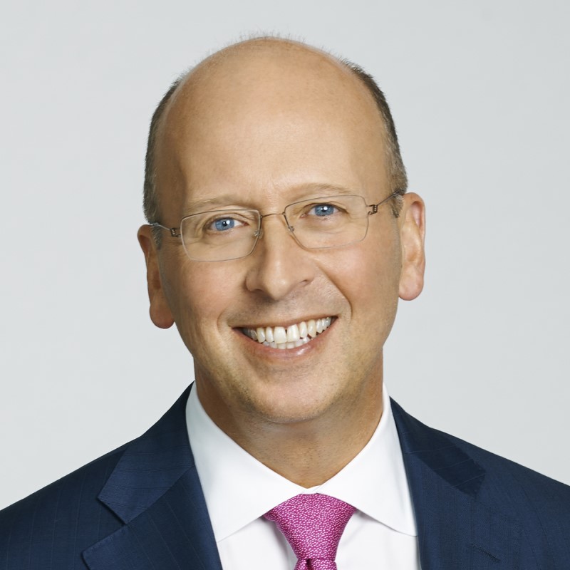 A man, Victor G. Dodig, wearing dark blue jacket and pink tie