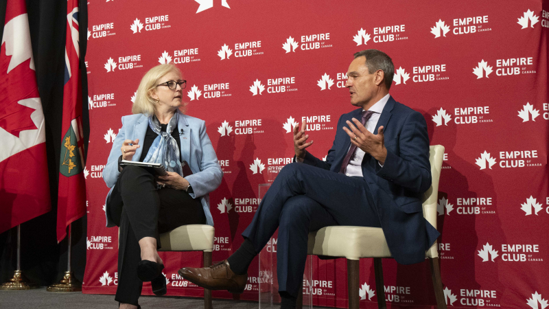 A man and a woman sitting on a stage, engaging in a conversation